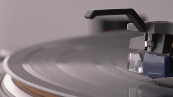 宏拍的乙烯唱片在转盘上旋转 线圈盒正在提升乙烯 背景上的红外光 — 图库视频影像