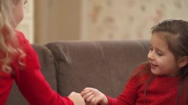 Little girls are playing rock paper scissors game and hugging each other