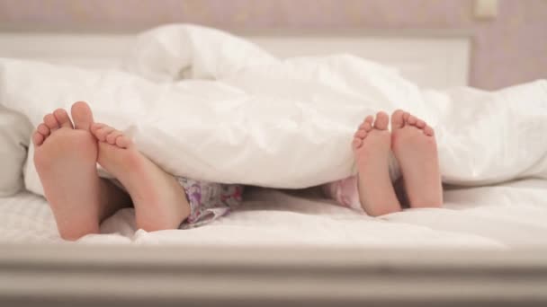 Two Pairs Small Feet Stick Out Blanket — Video Stock
