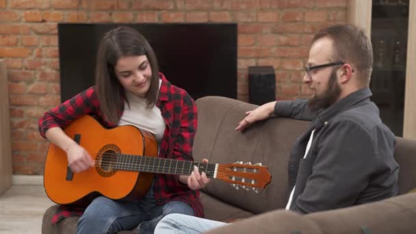 Young Girl Plays Acoustic Guitar Man Looks Her Moves Beat — Stock Video