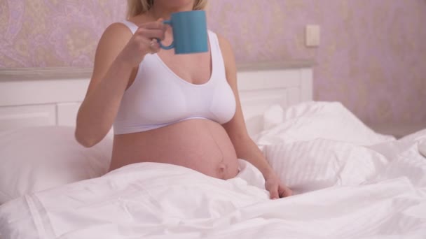 Charming Pregnant Blonde White Tank Top Sitting Bed White Linen — Video