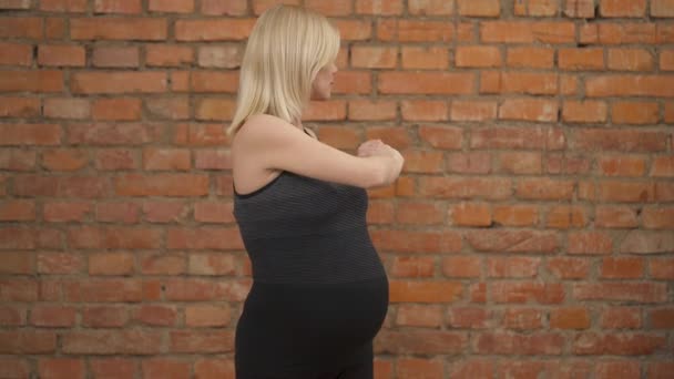 Una Encantadora Rubia Embarazada Camiseta Oscura Pie Sosteniendo Los Brazos — Vídeo de stock