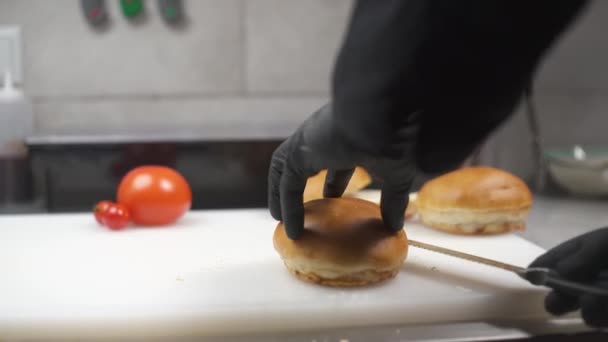Ruce Černých Rukavicích Horizontálně Rozřezávají Buchtičku Půlky Nožem Výroba Hamburgerů — Stock video