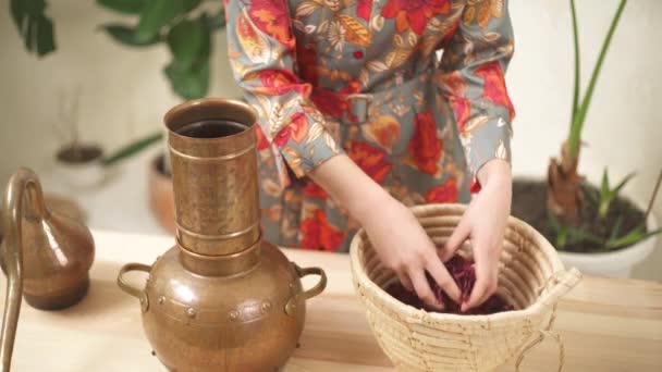 View Woman Filling Copper Alembic Dried Rose Petals Taken Wicker — стоковое видео