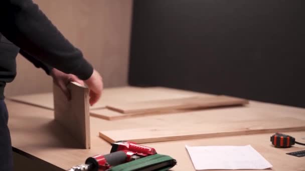 2枚の板を取り 釘銃で直角に接合する大工の側面図 — ストック動画