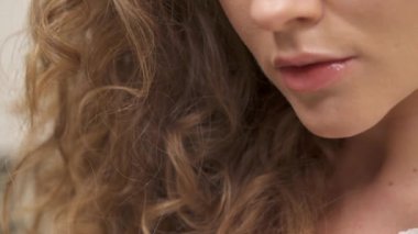 Bottom up shooting of a charming young woman with green eyes and natural curly hair