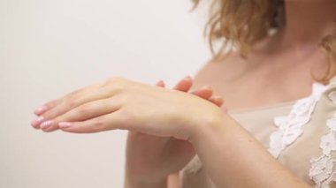 A close-up of a woman using natural yellow hand cream. The concept of home skin care.