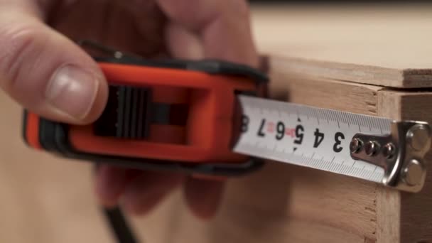 柔軟な定規で人の手の測定のクローズアップ木製のワークの長さ — ストック動画