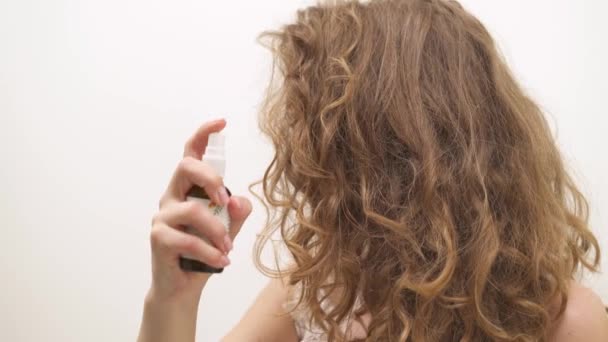 Demonstração Mulher Pulverizando Hairspray Cabelo Encaracolado Longo Fundo Branco Virando — Vídeo de Stock