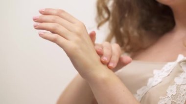 A close-up of a woman applying moisturizing hand cream into skin. The concept of home skin care.