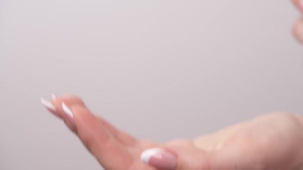 女性の手が瓶を持ち 手に泡を絞るのを閉じる — ストック動画