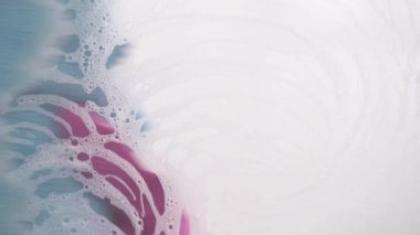 Cleaning soapy foam glass with a blue household cleaning cloth, a close-up demonstration video