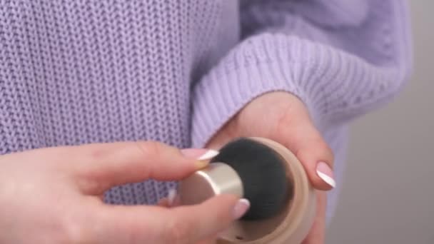 女性の手の正面図は 顔のコンパクトな粉を保持し それに化粧品ブラシを入れて — ストック動画