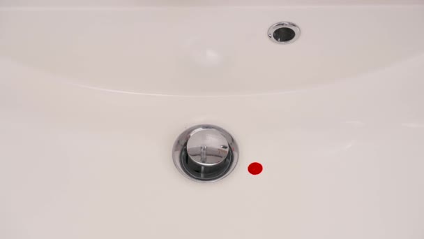 Ένα Κοντινό Πλάνο Κόκκινες Σταγόνες Πέφτουν Ένα Λευκό Νιπτήρα Μπάνιου — Αρχείο Βίντεο