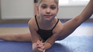 A demonstration video of a professional gymnast performing the heel stretch. Professional sport routine concept