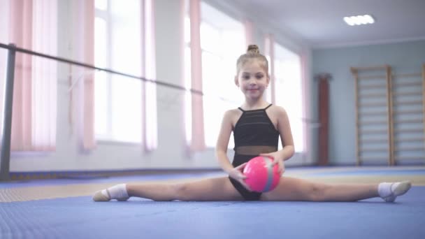 Cute Cheerful Girl Doing Rhythmic Gymnastics Exercises Ball Sitting Straddle — ストック動画