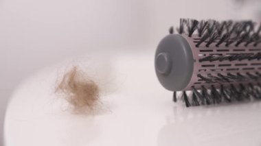 Beyaz yüzeye dökülen tüyler. Saç dökülme problemi. Kadın sağlığı ve güzelliği.
