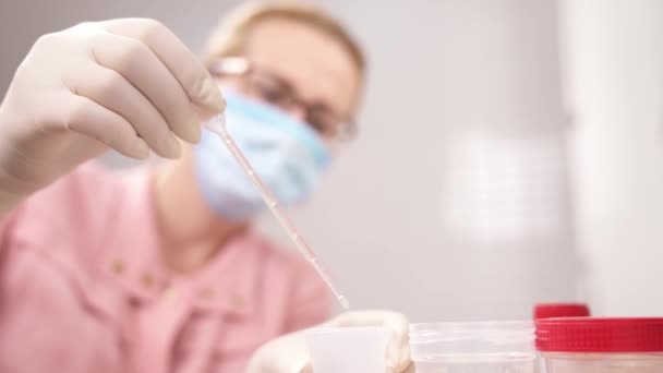 一个医学实验室科学家把尿样丢进杯子的演示视频 — 图库视频影像