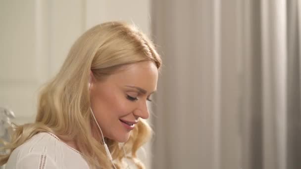 Боковой Снимок Молодой Блондинки Светлом Элегантном Интерьере Наслаждающейся Любимой Музыкой — стоковое видео