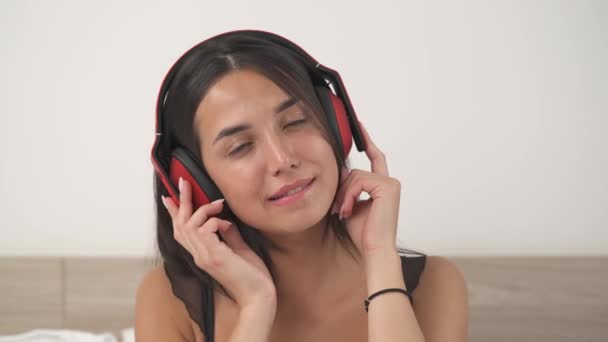 年轻性感女子头戴耳机欣赏音乐的最下面照片 — 图库视频影像