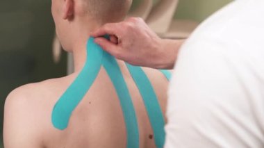 Kinesio bandını çıkaran bir terapistin gösteri videosu. Kinesio terapisi ve sağlık hizmeti. Ağrı kesici.