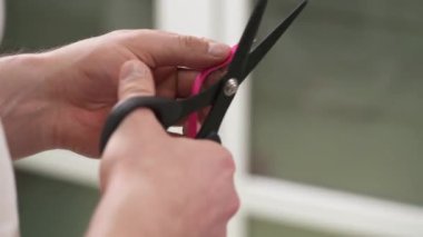 Profesyonel bir terapist pembe Kinesio bant kesiyor. Kinesio terapisi, hazırlık, tıbbi bant kullanımı