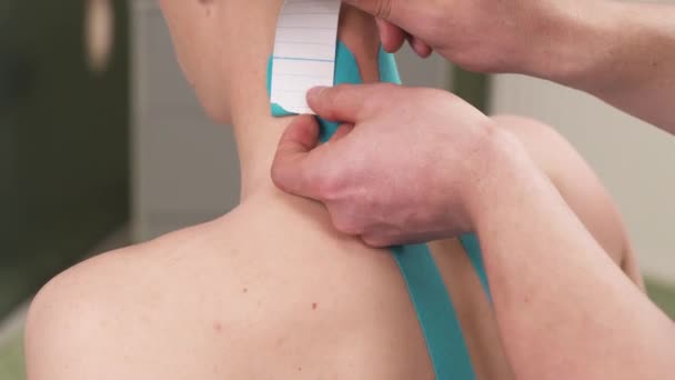 Profesyonel Bir Fizyoterapist Hastaların Boynuna Omzuna Esnek Kineziyoloji Bandı Yapıştırıyor — Stok video