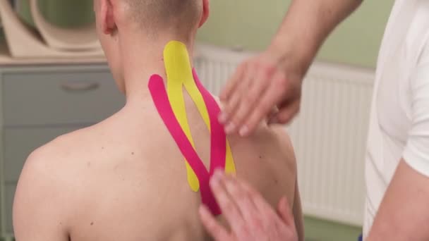 Hastanın Boynundaki Renkli Kineziyoloji Bandını Düzelten Bir Terapist Servikal Omurga — Stok video