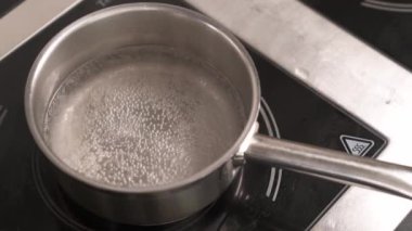 Su tavada kaynamaya başlar. Yemek pişirmek. Malzemeler hazırlanıyor. Yakın çekim gösteri videosu.