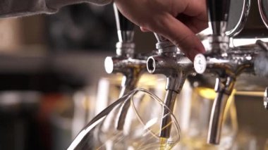 Barmenlerin ellerinin bardağı tutarken ve musluktan bira dökerken en alttaki pozu. Yakın çekim gösteri videosu