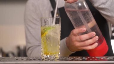 Bir barmenin, soda sifonundan bardağa taze limonata dökerken ki yakın çekimi..