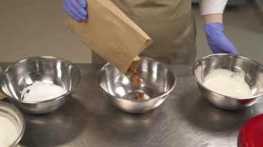 Profesyonel bir metal mutfak kasesini kurutulmuş incirlerle dolduran fırıncının tepesinden bir manzara. Mutfağa koşun. Malzemeler fırın için hazırlanıyor