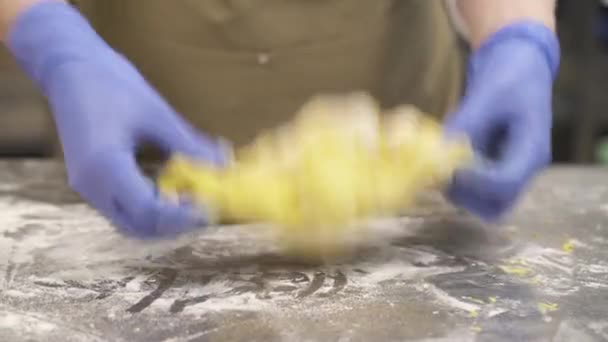 パン生地の一部を編んだ紫色の料理用手袋でパン職人の手のクローズアップデモビデオ 料理のコンセプト — ストック動画