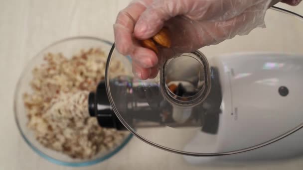それをブレンドするためにアーモンドと女性の手の充填食品加工機のトップビュー アーモンドミルクの準備だ ベジタリアン製品 健康的な栄養コンセプト — ストック動画