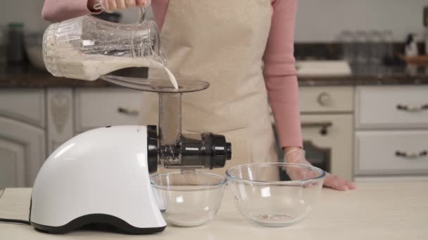 アーモンドナッツのプロセスをブレンド 美しいキッチンでアーモンドミルクを作る若い女性 自家製の健康食品 — ストック動画