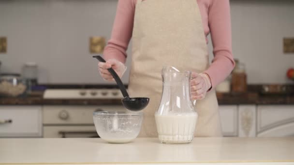여자가 그릇에서 국자와 아몬드 우유를 물통에 부었습니다 클로즈업 비디오 — 비디오