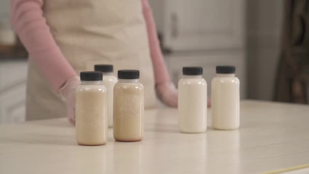 젖병으로 채워진 우유를 나머지 사람들에게 여성의 클로즈업 — 비디오