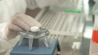 Çok amaçlı mikseri mini test tüpleriyle dolduran bir tıp teknolojisi uzmanı. Bilimsel araştırma kavramı