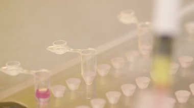 Bir laboratuvar teknisyeninin küçük bir test tüpünü gerekli miktarda biyolojik numuneyle doldurması. Tıbbi araştırma performansı