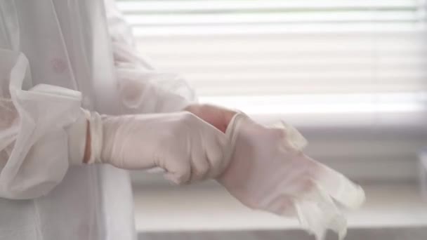 白い滅菌ラテックスの手袋に制服を着た医師のクローズアップ — ストック動画