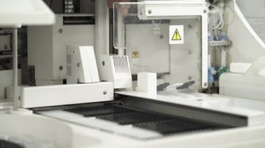 Otomatik analiz cihazının çalıştığını gösteren yakın çekim bir video. Laboratuvar yüksek teknoloji tıbbi ekipmanları. Bilimsel ve sağlık araştırma konsepti.