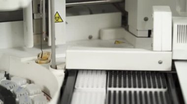 Tıbbi laboratuardaki otomatikleştirilmiş kimya analiz sürecinin yakın çekimi. Profesyonel tıbbi ekipman. Sağlık sigortası konsepti. İnsan biyolojik örnekleri analiz ediyor.