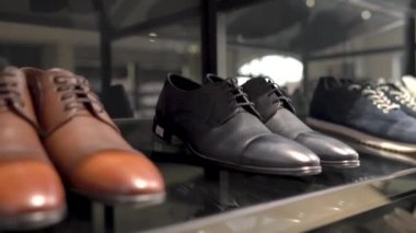 Lüks bir butikte klasik tarz siyah deri ayakkabı giyen bir erkek kostümcü. Üst alt kamera görüntüsü