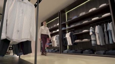 Erkek moda dükkanının yakışıklı genç müşterisi satın almadan önce kahverengi deri ayakkabı deniyor. Değişik seçenekler. Alışveriş ve satış konsepti.