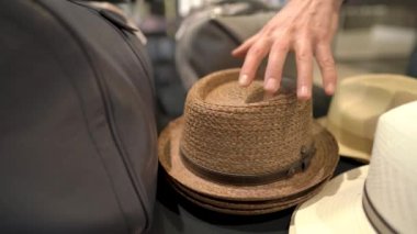 Pahalı bir erkek giyim mağazasında şık bir şapka giyen bir erkek. İzole edilmiş, bulanık arkaplanda