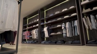 Erkek giyim mağazasının vitrininde şık iç mimarisi olan bir müşteri. Değişik seçenekler. Kıyafet gösterisi. Marka erkek kıyafetleri butiği.