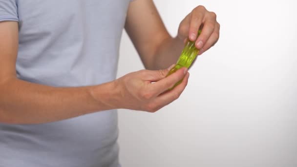 手里拿着绿色黏液的人 透明的玩具 在白色背景下孤立无援 — 图库视频影像