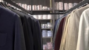Butikte erkek giysisi seçimi yapılan yakın çekim gösteri videosu. Pahalı kıyafetler, lüks takım elbiseler.