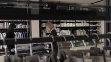 Dükkan sahiplerinin yeni erkek kıyafetleri koleksiyonunu olduğu yerde tutmalarının yan görüntüsü. Yeni bir kıyafet koleksiyonu alıyorum. Lüks moda mağazası kavramı