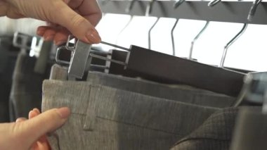 Butikte askıdaki erkek pantolonlarının çeşitliliği. Yakın çekim gösterisi. Lüks moda mağazası kavramı